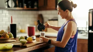Donna in cucina che prepara un pasto con proteine e frutta